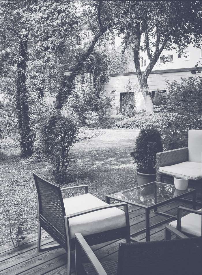 Eine Terrasse und der Blick in den angrenzenden Garten in schwarzweiß